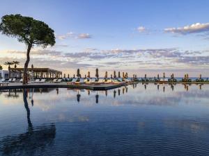 een groot waterlichaam met stoelen en een boom bij Rixos Park Belek - The Land Of Legends Access in Belek