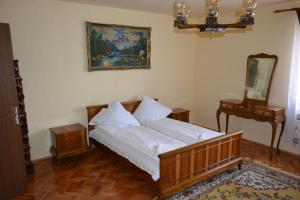 a bedroom with a wooden bed and a mirror at Casa Miki in Haţeg