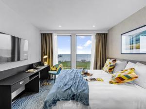 ペイントンにあるibis Styles Paigntonの大型ベッド、デスク、窓が備わるホテルルームです。