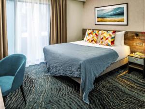 ペイントンにあるibis Styles Paigntonのベッドと椅子のあるホテルの部屋