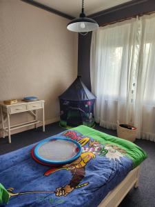 une chambre d'enfant avec un lit avec un cerf-volant dessus dans l'établissement Caz'Amor, à Saint-Sylvestre-sur-Lot