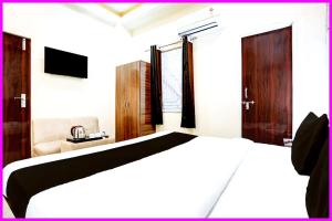 a bedroom with a white bed and a chair at Hotel Chankaya BNR Palace - Jagannath Temple - Sea Beach - Swimming Pool- Restaurant - Lift And Parking Facilities - Fully Air Condition with All Luxury Luxuary Rooms With Attached-Balcony - A Top Rated Hotel in Kathmandu
