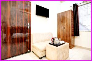a living room with a couch and a tv in a room at Hotel Chankaya BNR Palace - Jagannath Temple - Sea Beach - Swimming Pool- Restaurant - Lift And Parking Facilities - Fully Air Condition with All Luxury Luxuary Rooms With Attached-Balcony - A Top Rated Hotel in Kathmandu