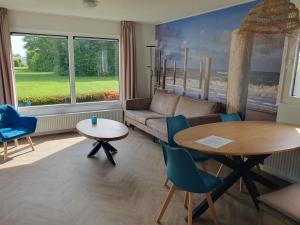ein Wohnzimmer mit Sofa und Tisch in der Unterkunft Chalet 87 in Petten