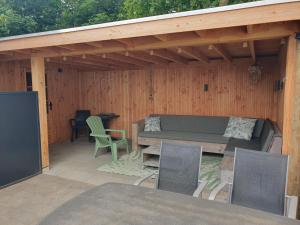 eine Terrasse mit Sofa, Tisch und Stühlen in der Unterkunft Chalet 87 in Petten + 6 Fotos