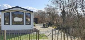 ein kleines Haus mit einem Tisch und einem Zaun in der Unterkunft J 071 in Petten