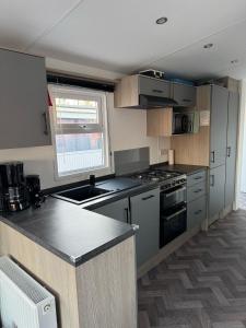 a kitchen with a sink and a stove top oven at Chalet 82 in Petten