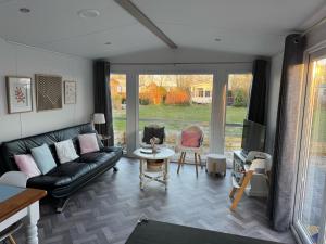 a living room with a couch and a table at Chalet 82 in Petten