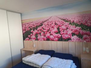 ein Zimmer mit einem Gemälde eines Feldes rosa Tulpen in der Unterkunft Chalet 87 in Petten