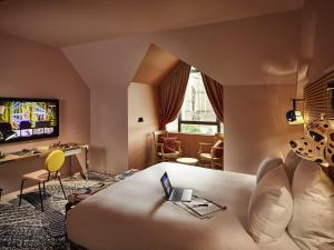 a hotel room with a couch and a tv at Mama Shelter Dijon in Dijon