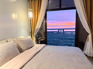 a bedroom with a bed and a window with a view at Sunset Hill Cabins in San Fabian