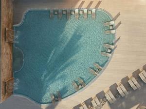 une vue aérienne d'une piscine avec des chaises longues dans l'établissement Hyde Ibiza, à Cala Llonga