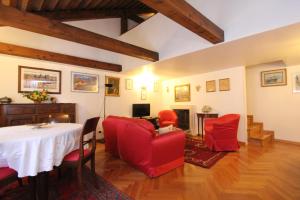 ein Wohnzimmer mit einem Tisch und roten Stühlen in der Unterkunft Zoia Terrace view on St Marks Basilica 150mt in Venedig