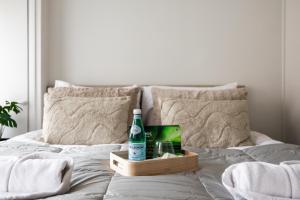 eine Flasche Bier in einem Tablett auf einem Bett in der Unterkunft Snowlight Apartment By BookLapland in Rovaniemi