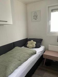 a bedroom with a bed with a flower on it at Chalet 130 in Petten
