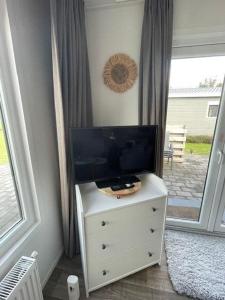 a tv on top of a dresser in a room at Chalet 130 in Petten