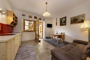 a kitchen and living room with a couch and a table at Baumannhof Mooskofel - adults only in Plazzoles