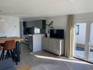Eine Küche mit Tisch, Fernseher und Arbeitsplatte in der Unterkunft J121 in Petten