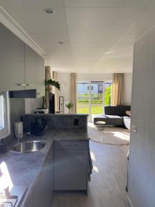 eine Küche mit Spüle und ein Wohnzimmer in der Unterkunft J121 in Petten