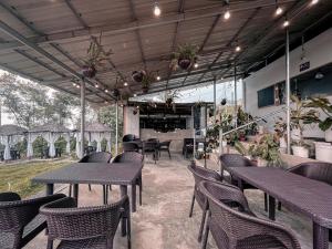 a group of tables and chairs in a restaurant at Sunset Hill Cabins in San Fabian
