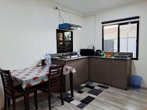 cocina con mesa, mesa y sillas en Nav's B&B, en Nadi