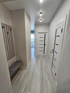 un couloir vide avec deux portes et un banc dans l'établissement Квартира в Рівному біля луцького кільця, à Rivne