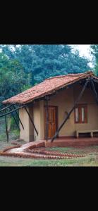 a small house with a large roof and a door at Sakhua in Tāla