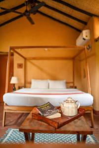 1 dormitorio con 1 cama y una mesa con hervidor de agua. en Sakhua, en Tāla