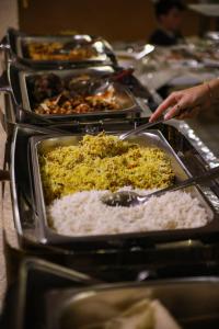 a person reaching for a tray of food with rice at Modern private bedouin camp in Al Raka +31 photos