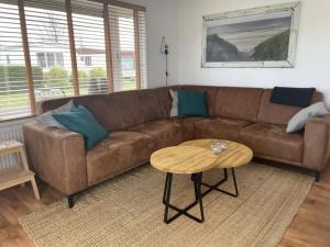 ein braunes Sofa in einem Wohnzimmer mit einem Tisch in der Unterkunft J 134 in Petten + 6 Fotos
