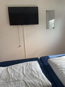 ein Schlafzimmer mit einem Bett und einem Flachbildfernseher an der Wand in der Unterkunft J 134 in Petten