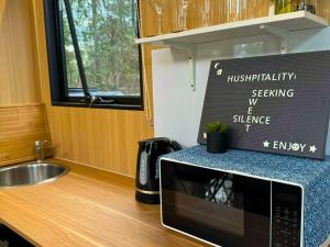 eine Mikrowelle in einer Küche mit einem Schild darauf in der Unterkunft Tranquility Ranch by Tiny Away in Wolfdene + 15 Fotos
