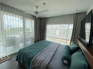 een slaapkamer met een bed en een groot raam bij The gallery condominium Ben in Jomtien Beach +23 foto's