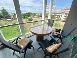 een balkon met een tafel en stoelen en uitzicht bij The gallery condominium Ben in Jomtien Beach