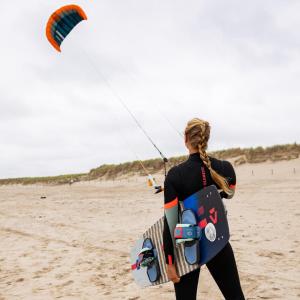eine Frau lässt am Strand einen Drachen steigen in der Unterkunft J 174 in Petten + 1 Foto
