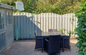 eine Terrasse mit Tisch und Stühlen und einem Zaun in der Unterkunft J 174 in Petten
