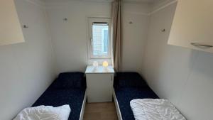 ein kleines Zimmer mit zwei Betten und einem Fenster in der Unterkunft J 174 in Petten