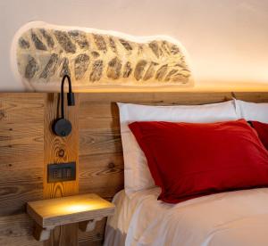 a bedroom with a bed with a red pillow and a lamp at Le Grenier d'Antan - Relax Suite in Aosta