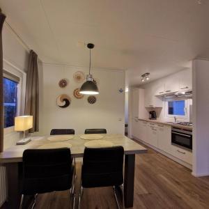 a kitchen and dining room with a table and chairs at Chalet 216 in Petten