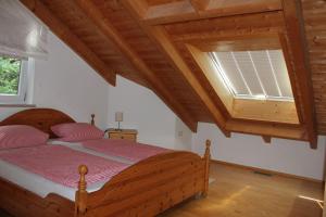 a bedroom with a wooden bed and a window at Ferienwohnung Wühn in Teisendorf