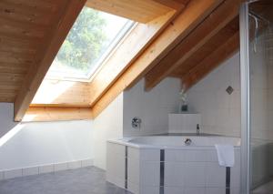a bathroom with a bath tub and a window at Ferienwohnung Wühn in Teisendorf +10 photos