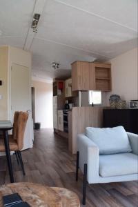 a living room with a couch and a kitchen at Chalet 217 in Petten