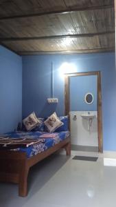 a blue bedroom with a bed and a sink at Sylvan homestay mawlynnong in Mawlynnong