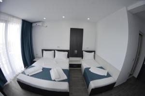 two twin beds in a room with a window at Vila Rares in Costinesti +20 photos
