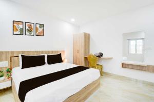 a bedroom with a large bed and a yellow chair at Townhouse Oak NFC Crossway Hyderabad in Maula Ali +8 photos