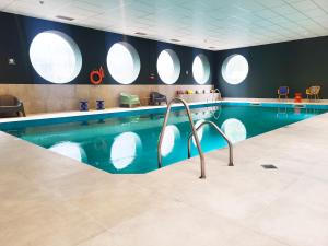 アイントホーフェンにあるHoliday Inn Eindhoven Centre by IHGの円形の窓があるホテルのプール