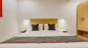 ニューデリーにあるGolden World Hotelの大きな白いベッドと枕が2つある寝室