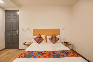 ニューデリーにあるGolden World Hotelのベッドルーム1室(カラフルな掛け布団付きのベッド1台付)