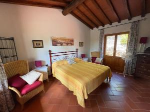 a bedroom with a bed and two chairs and a window at Villetta Lilla' in Impruneta