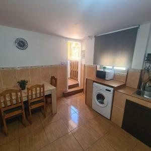 a kitchen with a table and a washing machine at Villa Mallorquina tu zona para desconectar 